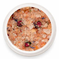 Bowl of bath salts with flowers on a white background
